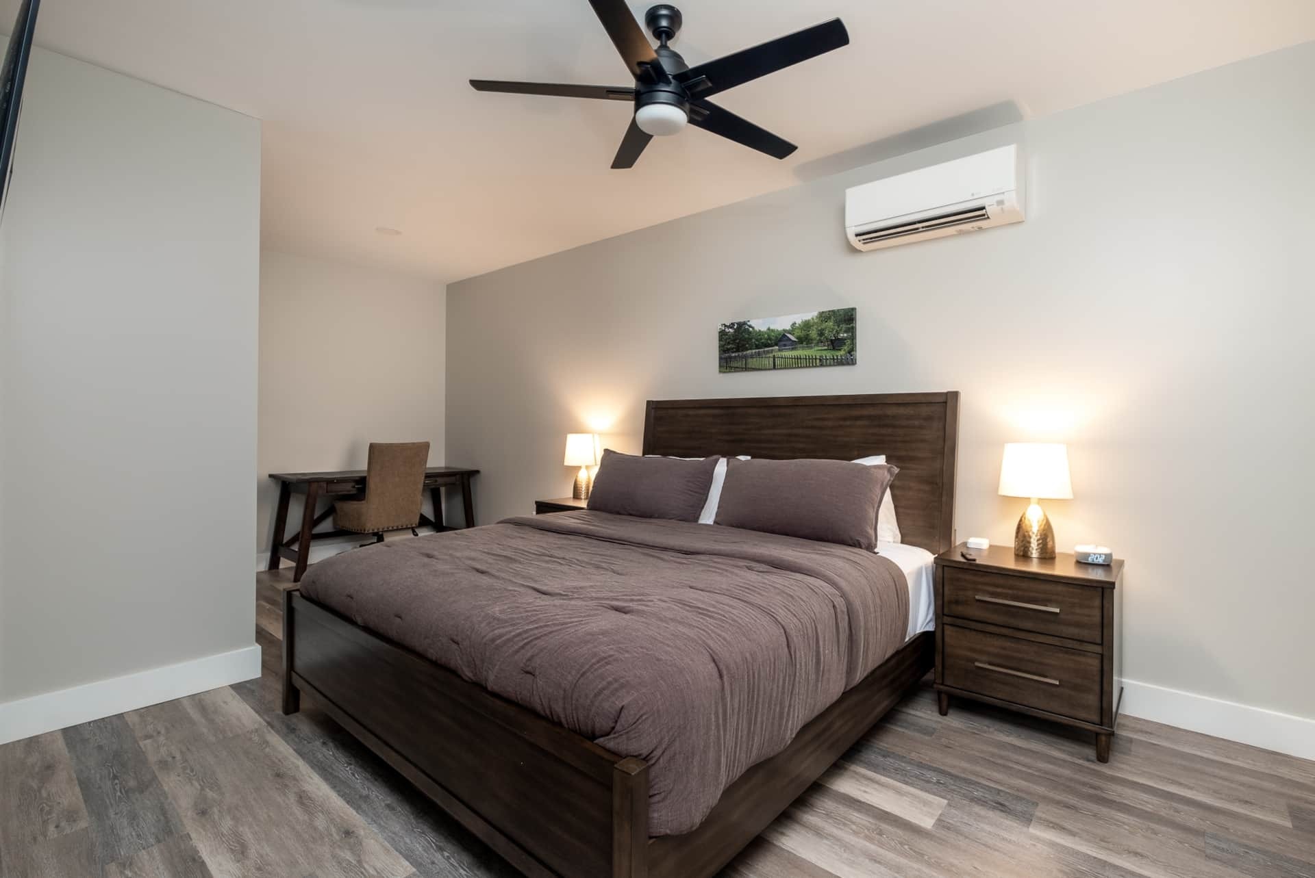 Primary bedroom with king bed and dark wood furniture