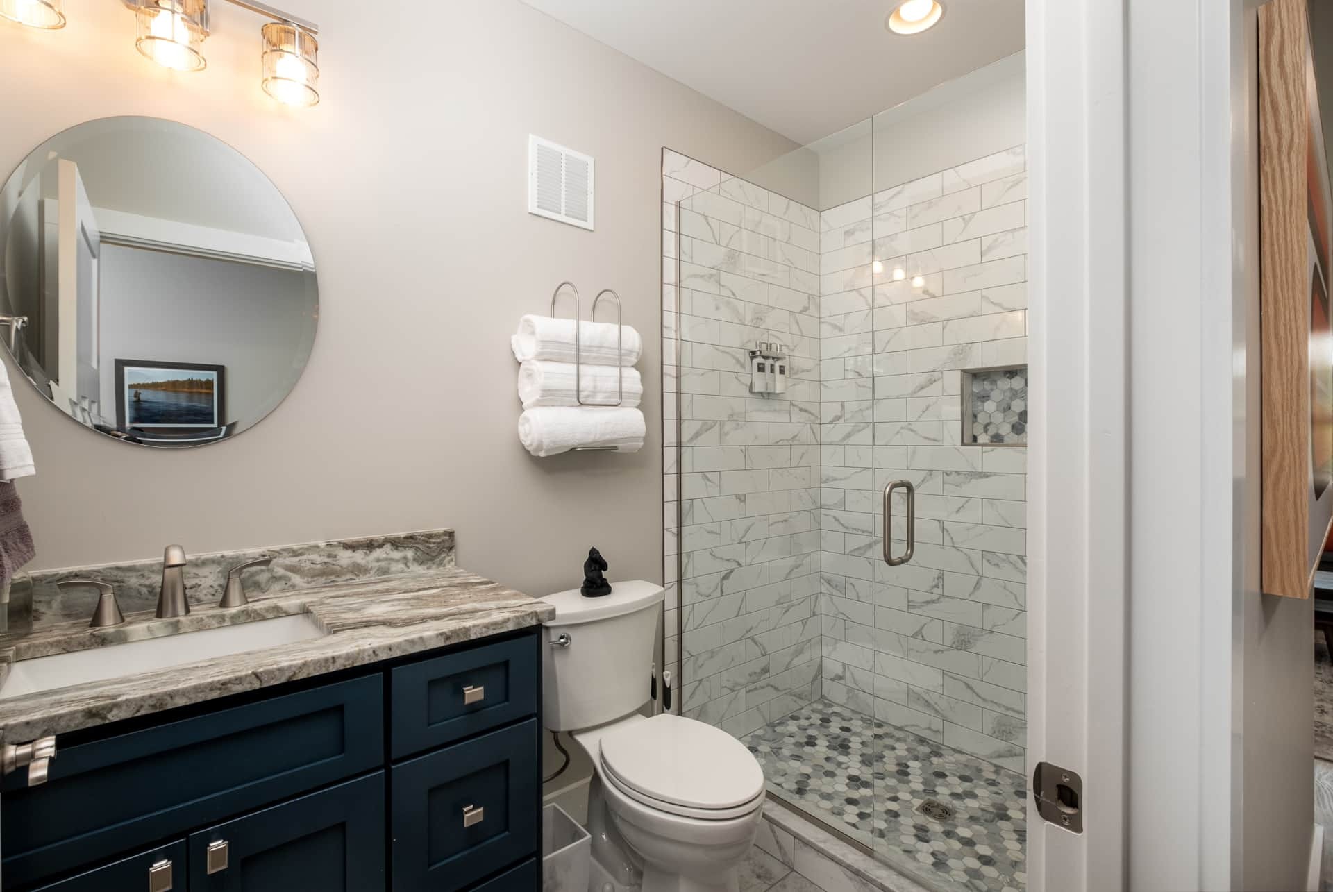 Bathroom with walk-in shower and navy vanity