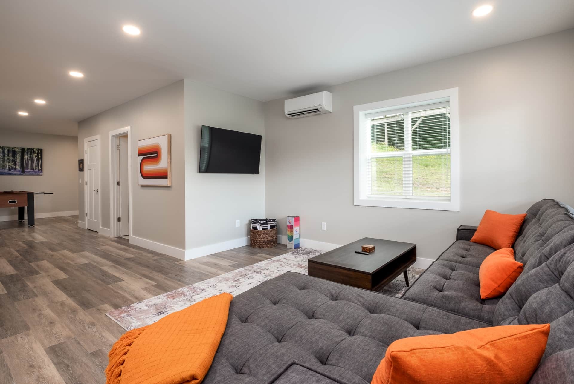 Lower-level rec room with sectional and mounted TV