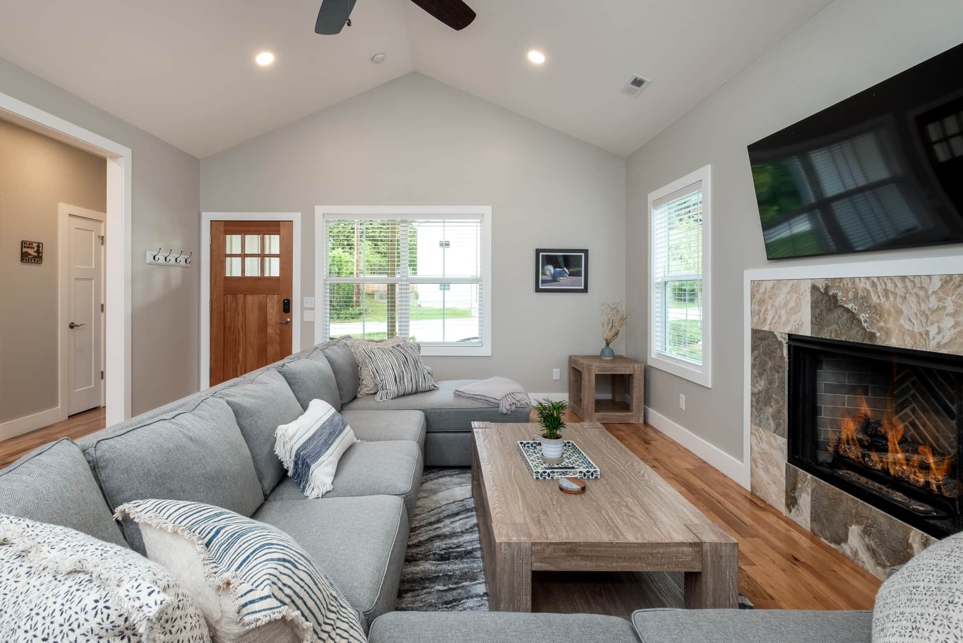 Great room with vaulted ceiling, fireplace, and open kitchen view