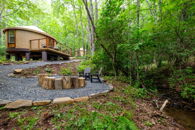 Yurt exterior beside the creek with fire pit