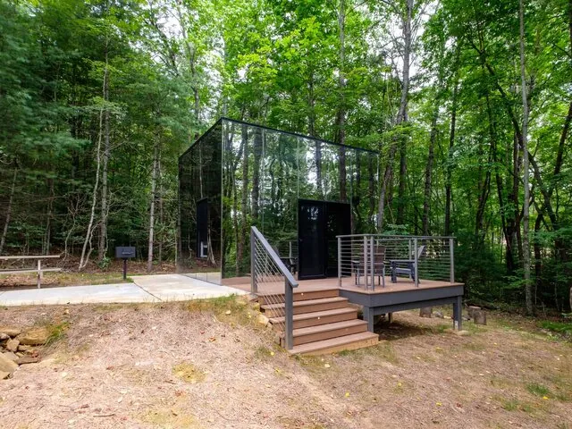 Mirror Cabin exterior reflecting surrounding forest at Valley Bear Farms