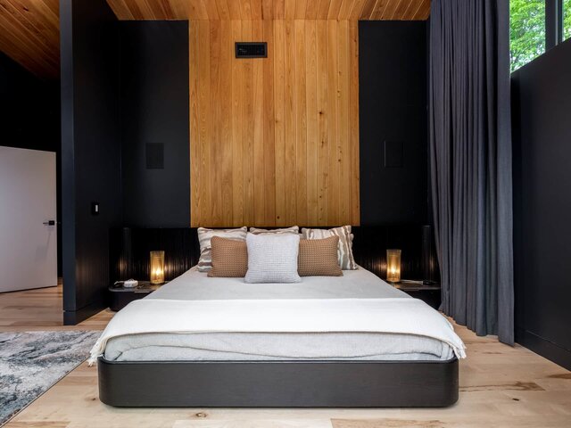 King bedroom with dramatic wood paneling